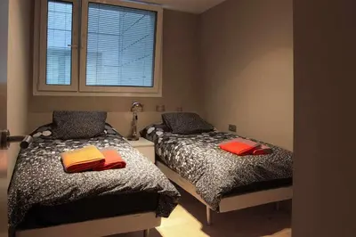 a bedroom with two beds and a window at PASSEIG DE GRACIA SUN APARTAMENT BALCONY / 2 BEDROOMS in Barcelona