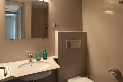 a bathroom with a sink and a toilet and a mirror at PASSEIG DE GRACIA SUN APARTAMENT BALCONY / 2 BEDROOMS in Barcelona