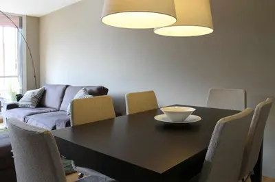 a dining room with a black table and chairs at PASSEIG DE GRACIA SUN APARTAMENT BALCONY / 2 BEDROOMS in Barcelona