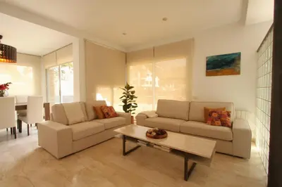 a living room with two couches and a table at Beach House Castelldefels in Castelldefels