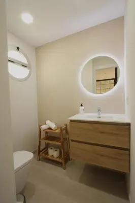 a bathroom with a sink and a toilet and a mirror at Beach House Castelldefels in Castelldefels