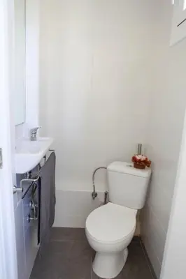 a white bathroom with a toilet and a sink at Barcelona Family Beach in Barcelona