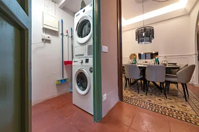a dining room with a table and a washing machine at Habitat Apartments Grace in Barcelona