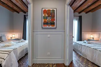 two beds in a room with white walls at Habitat Apartments Grace in Barcelona