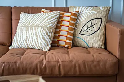 a brown couch with pillows on top of it at Habitat Apartments Grace in Barcelona