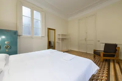 a bedroom with a large white bed and a chair at SibsBcn- Rambla- Family Friends Business Central in Barcelona