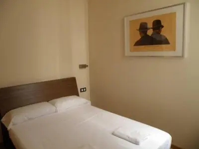 a bed in a bedroom with a picture on the wall at Hotel Center Gran Via in Barcelona