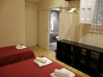 a room with two beds and a bathroom with a mirror at Hotel Center Gran Via in Barcelona