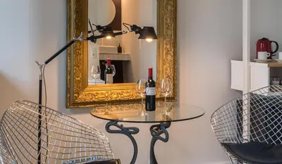 a table with two chairs and a mirror at Habitació amb encant in Sitges