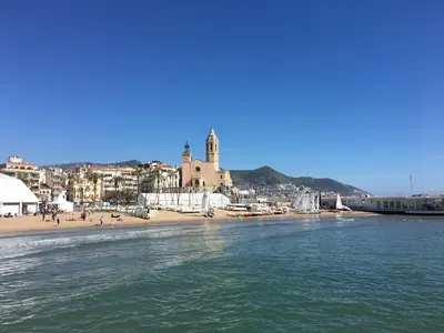 a view of a beach with a church and a city at Habitació amb encant in Sitges