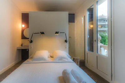 a bedroom with a white bed and a window at Habitació amb encant in Sitges
