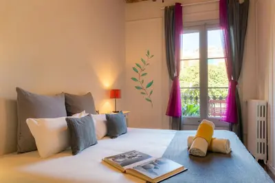 a bedroom with a large white bed with a window at Primavera Hostel in Barcelona