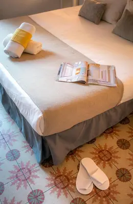 a bed with a pair of white shoes on it at Primavera Hostel in Barcelona