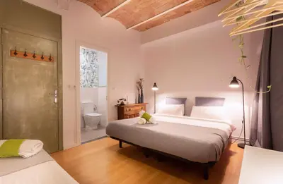 a bedroom with two beds and a bathroom at Primavera Hostel in Barcelona