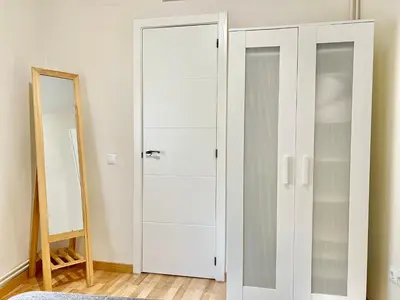 a white wardrobe in a room with a mirror at Comfortable renovated flat, WiFi! in Badalona
