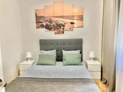 a bedroom with a bed with four paintings on the wall at Comfortable renovated flat, WiFi! in Badalona