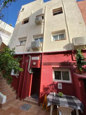 a red building with a table in front of it at Comfortable renovated flat, WiFi! in Badalona