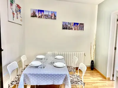 a white dining room with a table and chairs at Comfortable renovated flat, WiFi! in Badalona