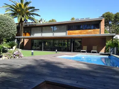 a house with a swimming pool in front of it at VILLA DEL BOSQUE in Castelldefels