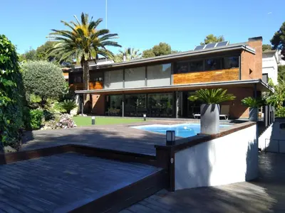 a house with a swimming pool in front of it at VILLA DEL BOSQUE in Castelldefels