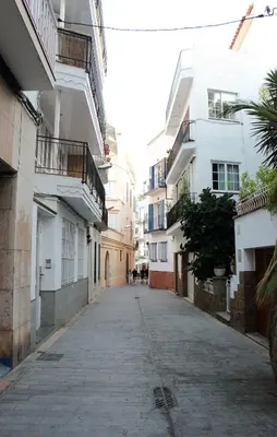 an empty street in a city with white buildings at Sitges Ático 2 min a Playa San Sebastían in Sitges