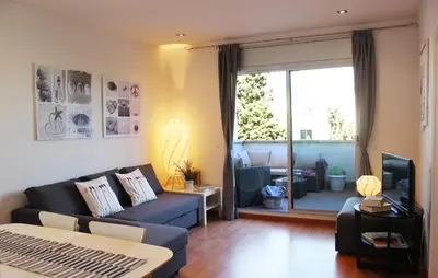 a living room with a couch and a tv at Sitges Ático 2 min a Playa San Sebastían in Sitges