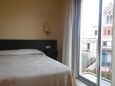 a bedroom with a bed and a large window at Hostal Sant Sadurní in Sant Sadurní dʼAnoia