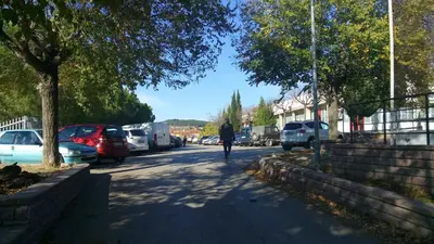 a person walking down a street with parked cars at Hostal Sant Sadurní in Sant Sadurní dʼAnoia