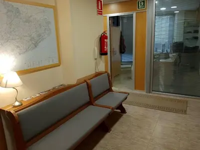 a waiting room with a bench and a lamp at Hostal Sant Sadurní in Sant Sadurní dʼAnoia