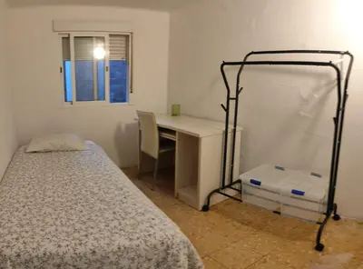 a bedroom with a bed and a desk with a desk at Pintor Pahissa Rooms in Barcelona