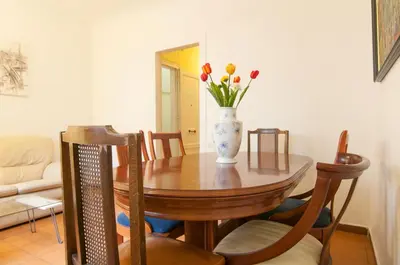 a dining room table with a vase of flowers on it at Pintor Pahissa Rooms in Barcelona