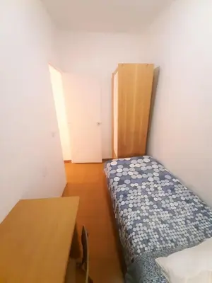 a small room with a bed and a table at Pintor Pahissa Rooms in Barcelona
