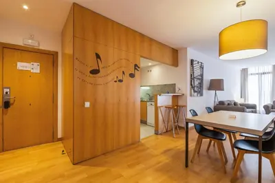 a living room with a table and a wooden door at Aspasios Plaza Real Apartments in Barcelona