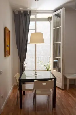 a dining room with a table and chairs and a window at Claris Apartments in Barcelona