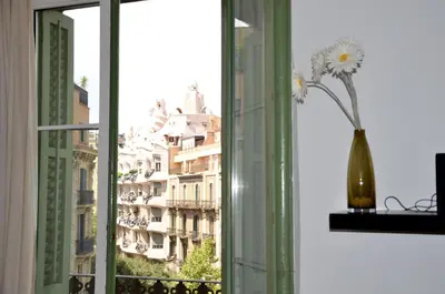 a vase of flowers on a window sill with a building at Claris Apartments in Barcelona