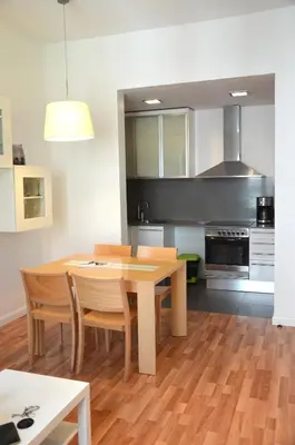 a kitchen with a wooden table and chairs in a room at Claris Apartments in Barcelona