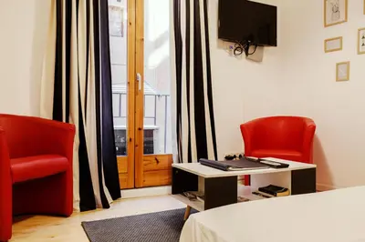 a room with two chairs and a bed and a window at Nice apartment in the middle of Born in Barcelona