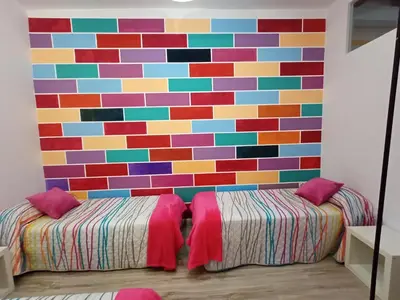 a room with a colorful wall with two beds at Fira Plaza España Apartment 3ʳᵈ Floor Balcony in Barcelona