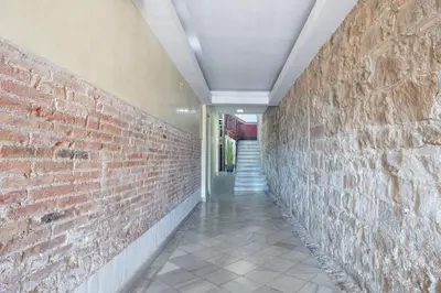 a hallway with a red brick wall and a staircase at Citytrip Barceloneta Beach in Barcelona