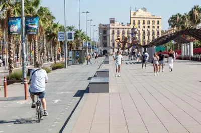 a group of people riding bikes down a street at Citytrip Barceloneta Beach in Barcelona