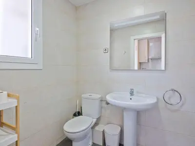 a white bathroom with a toilet and a sink at Citytrip Poble Nou Beach in Barcelona