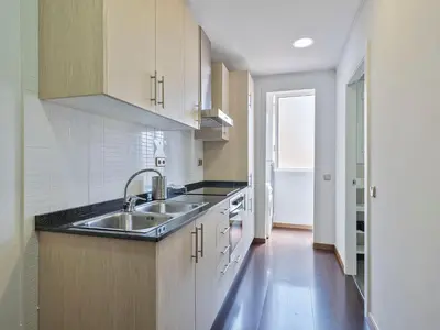 a kitchen with wooden cabinets and a sink at Citytrip Poble Nou Beach in Barcelona