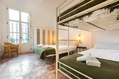 a bedroom with two bunk beds and a chair at bp1- Piso para Grandes Grupos in Barcelona