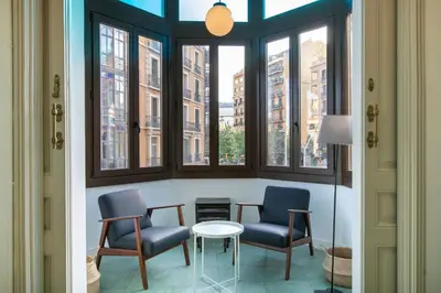 a room with two chairs and a table and windows at bp1- Piso para Grandes Grupos in Barcelona
