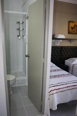 a bathroom with a bed and a shower and a toilet at Pensión Casa Blanca in Barcelona