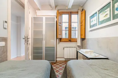 a room with two beds and a brick wall at Fuster Apartments by Aspasios in Barcelona