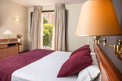 a bedroom with a bed with a lamp and a window at RVHotels Spa Vila de Caldes - Adults only in Caldes de Montbui