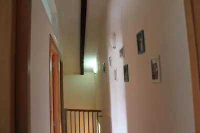 a hallway with a staircase with pictures on the walls at Old Navy House in Badalona