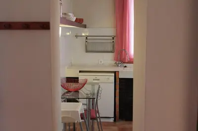 a kitchen with a counter and a table and chairs at Old Navy House in Badalona