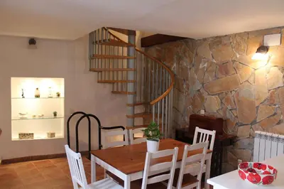 a dining room with a table and a stone wall at Old Navy House in Badalona